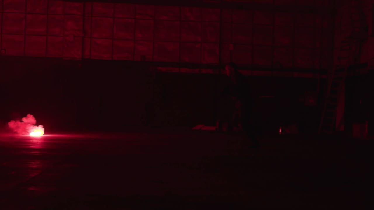 persona en una habitación oscura con luces rojas y humo