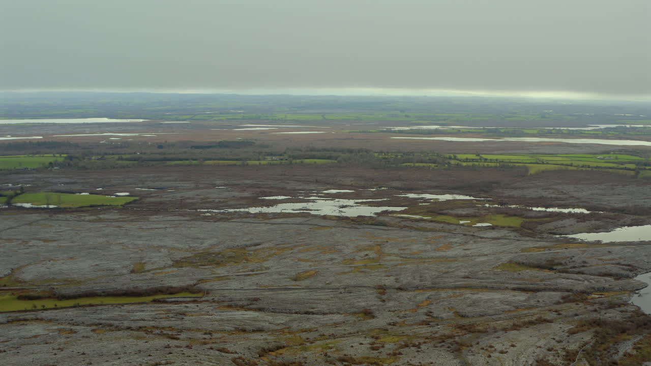 panorámica aérea a través del paisaje de burren que muestra los turloughs estacionales y las características de drenaje