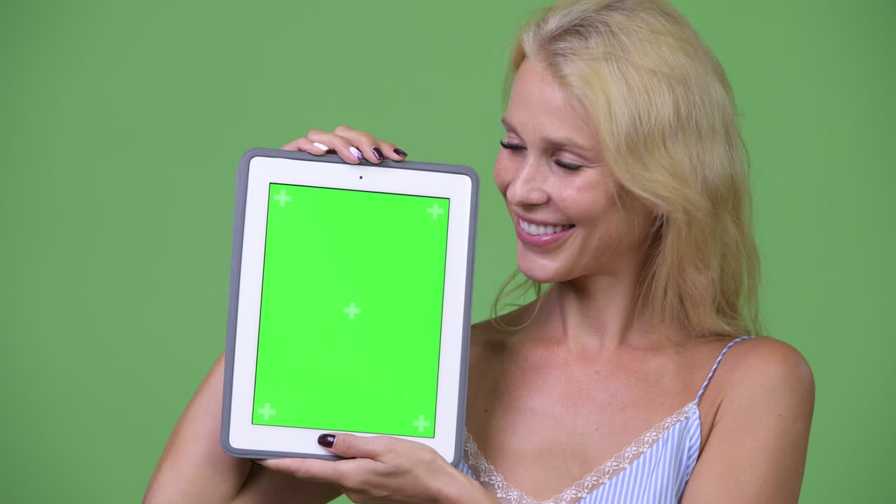 Young happy beautiful businesswoman showing digital tablet