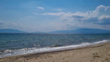 Olas-De-Mar-Tranquilas-Y-Cielo-Azul-Claro-En-Un-Día-Soleado-De-Verano-En-Una-Playa-De-Grecia