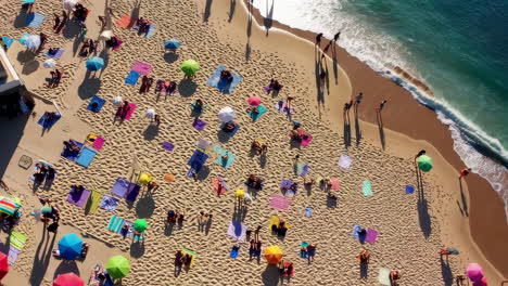 aerial view of a crowded beach with colorful umbrellas and people