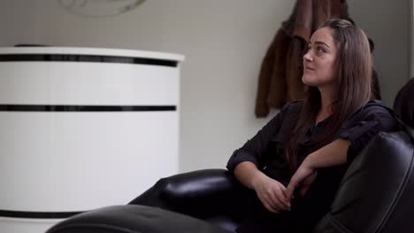hermosa joven sentada y relajándose en el sofá cerca de la recepción.
