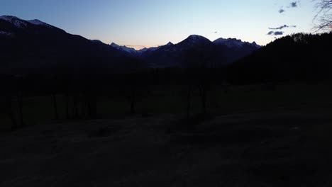 Drone-fly-towards-snowy-mountains-at-sunrise,-aerial-view-of-winter-mountain-background-landscape