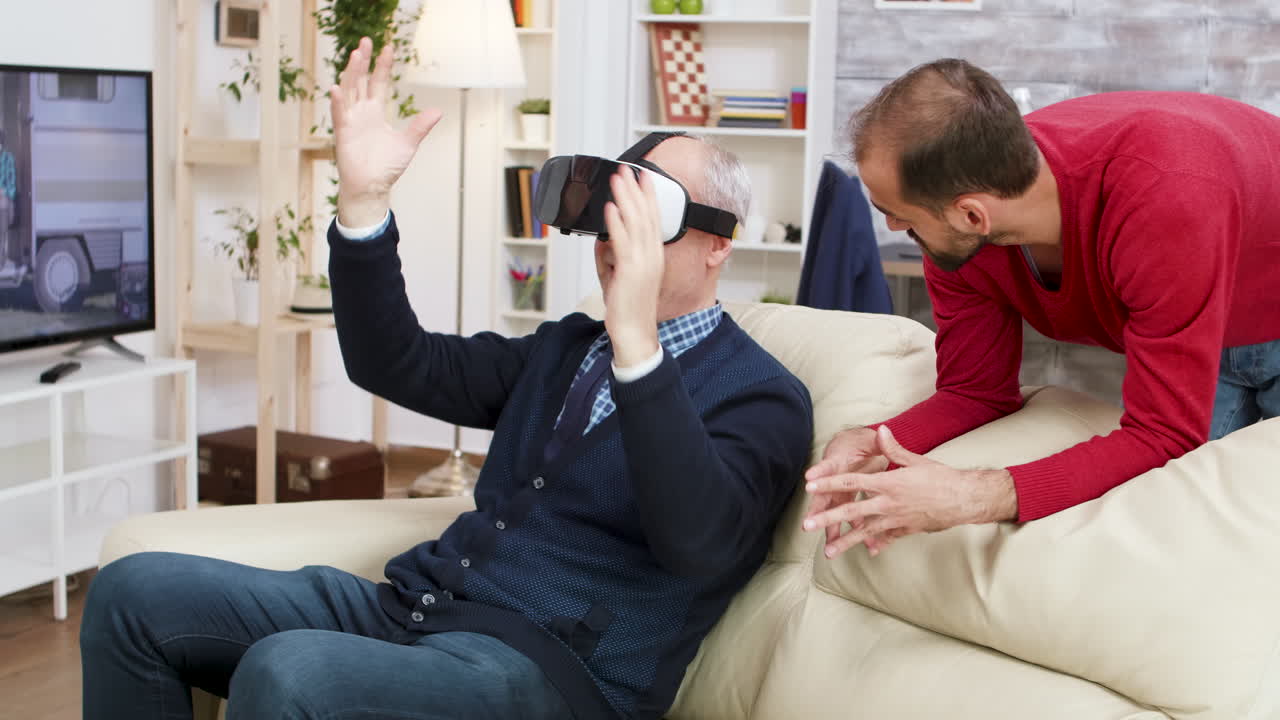 Senior man using virtual reality headset with son
