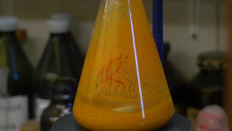 vidrio de laboratorio con un líquido naranja
