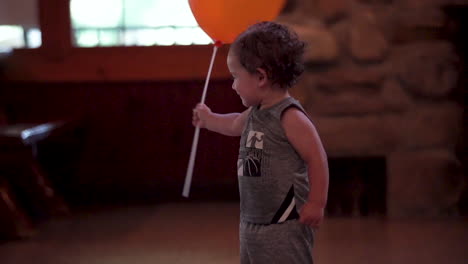 mexican-hispanic-biracial-toddler-boy-with-orange-balloon