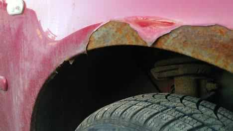 extremos traseros de las ruedas oxidadas durante las lluvias de un coche hatchback