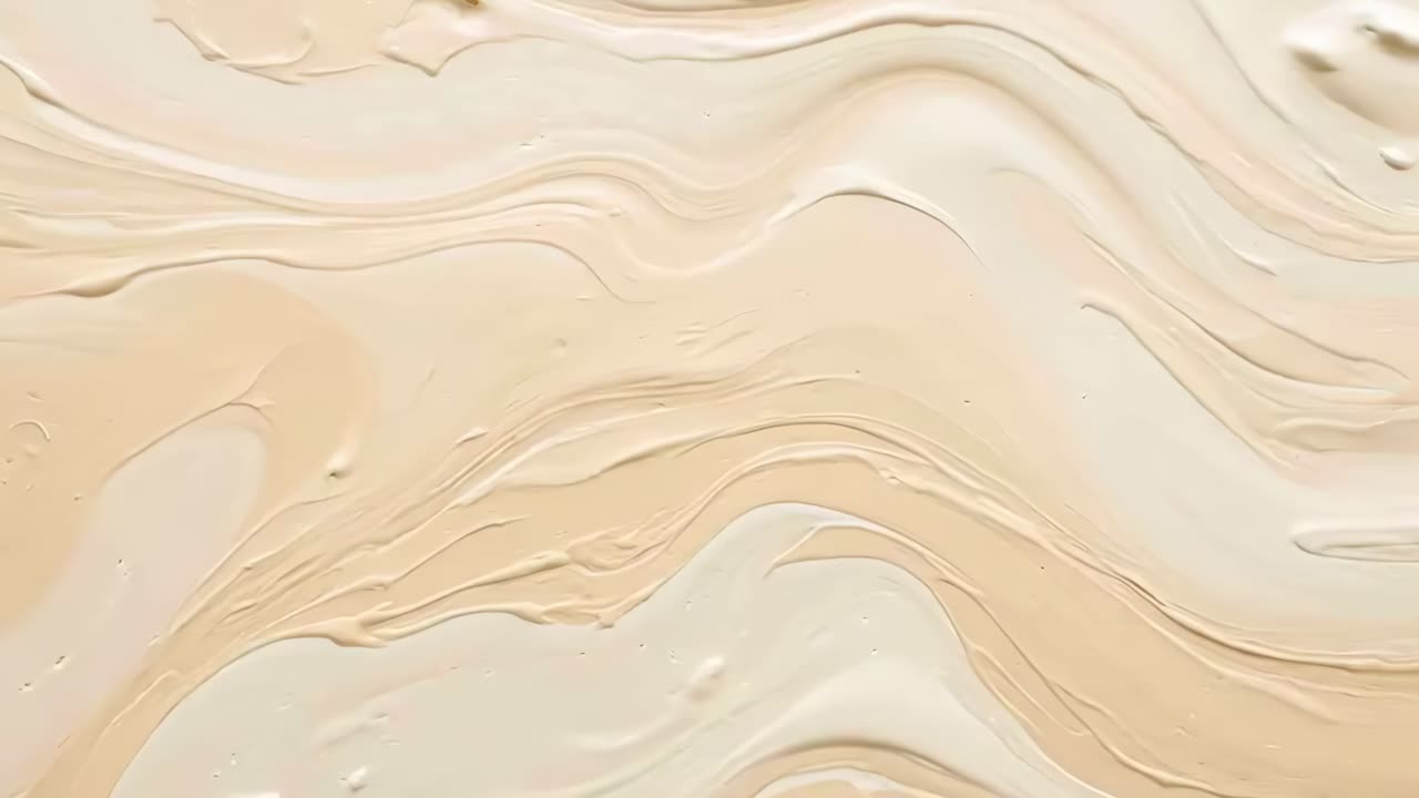 Top-down view of creamy beige paint swirls, creating a soothing abstract texture
