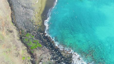 aerial of eroded coastline and green seaside fields on hawaii island