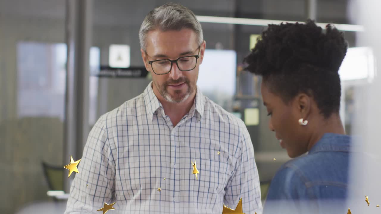 Man speaking pointing at desk in glass-walled office woman nodding gold stars sweeping for review