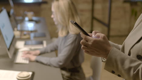 close up of female hands texting on mobile phone in the office