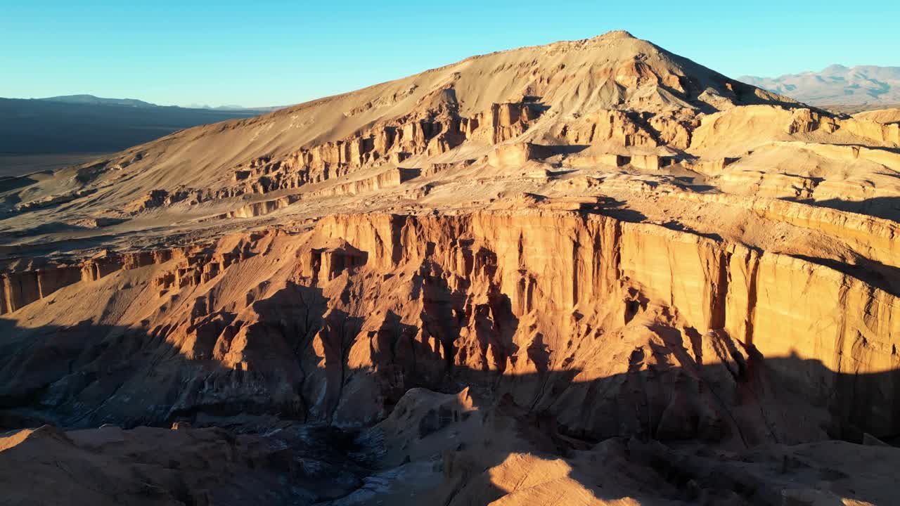 Majestic panorama of textured rock formations and reflective flats glowing under a vibrant desert sunset