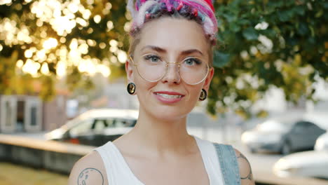 smiling woman with colorful dreadlocks and glasses