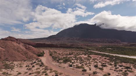 Aerial-view-of-the-landscape-in-Calchaquí,-Salta,-Argentina,-showing-the-road,-the-mountain-and-some-of-the-red-rocks