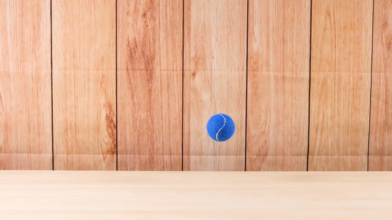 나무 벽에 부히는 파란 테니스 공