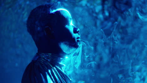 male model in shiny outfit posing in liquid sky laser light