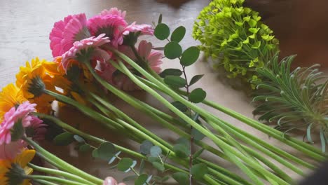 florista arreglando un ramo de margaritas gerbera transvaal sobre el hombro vista en cámara lenta 4k