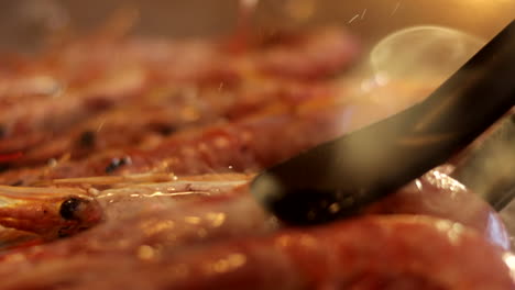 plano de detalle de cómo se dan vuelta las gambas mientras se prepara una paella