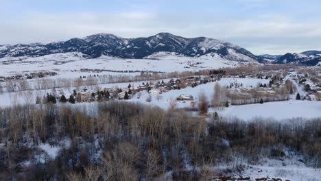 El-Invierno-Aéreo-De-Boseman-Montana-Se-Inclina-Hacia-Abajo-Sobre-Las-Casas-De-Los-Barrios-Suburbanos-Nevados,-Drones-De-4k-Sobre-Pescadores-De-Hielo-Y-Parque-De-Nieve-Con-Fondo-De-Montaña