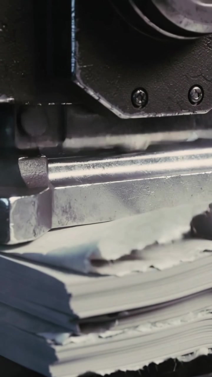 Vertical video: Press activating, driving punch through tied paper bundle on platen, binding sheets