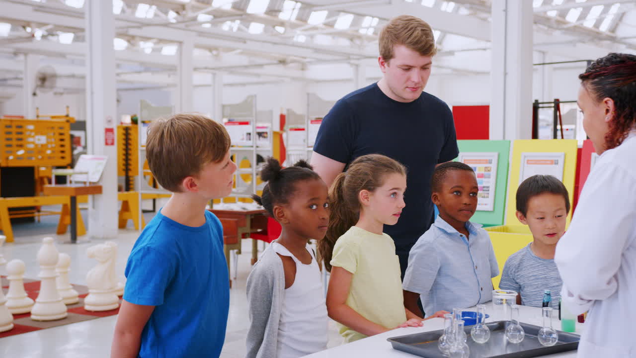 Lab technician explains experiment to kids at science centre