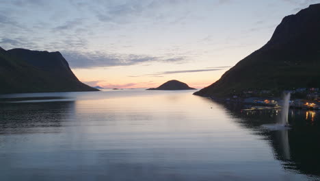 aerial dolly above idyllic coastal village of torsken norway at sunset, reflection on ocean