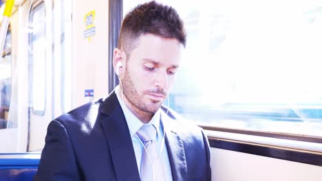 hombre de negocios escuchando música mientras viaja