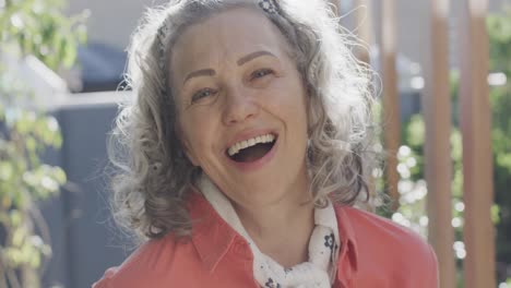 Portrait-of-happy-senior-caucasian-woman-looking-at-camera-and-lsughing,-slow-motion