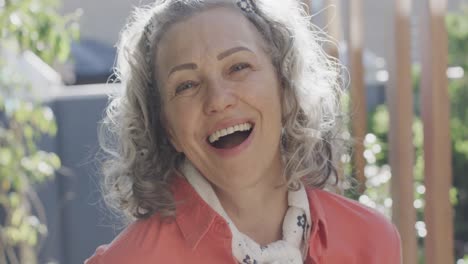 retrato de una mujer caucásica mayor feliz mirando a la cámara y suspirando, cámara lenta