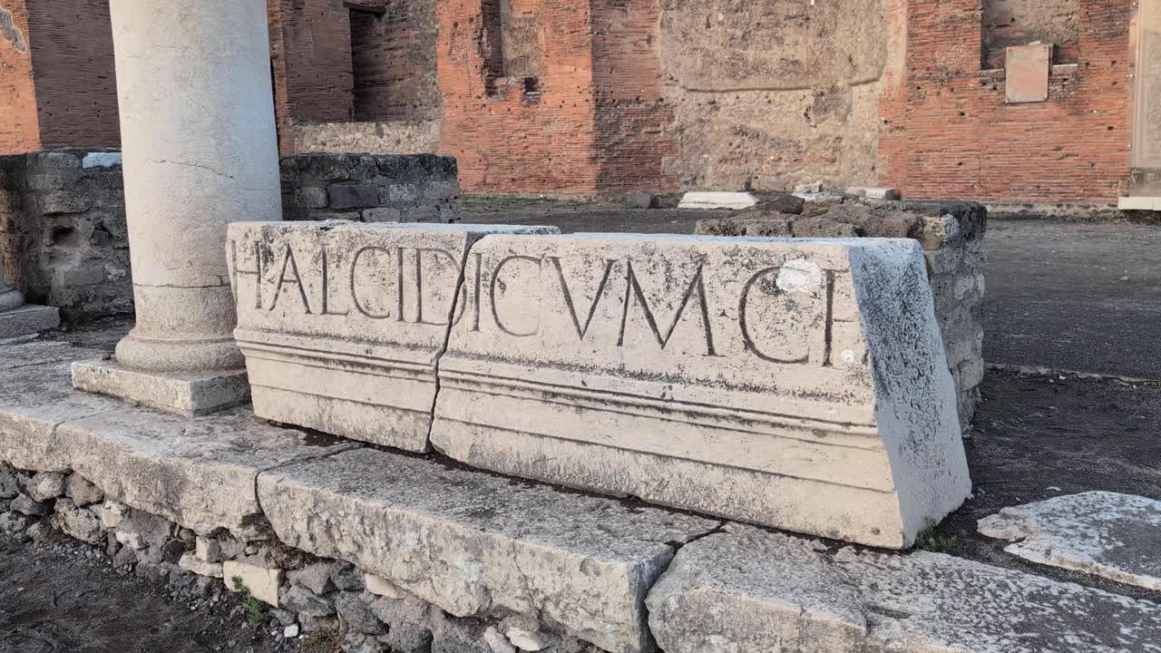 Slow pan right of a narrow stone street in Pompeii, Italy at golden hour, showing aged walls and cobblestones from the historic Roman city