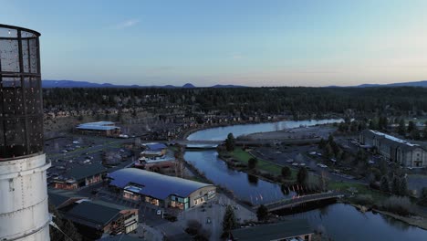 Drone-shot-of-an-American-flag-flying-over-Bend,-Oregon-at-daybreak