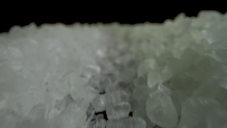 forward camera inside crystal coarse sea salt on black mirror table