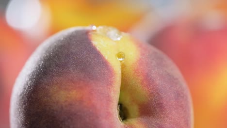 Water-drop-falling-of-nectarine-surface-in-slow-motion,-macro-shot