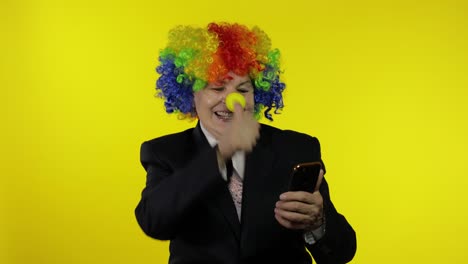 clown businesswoman freelancer receives money income while using mobile phone