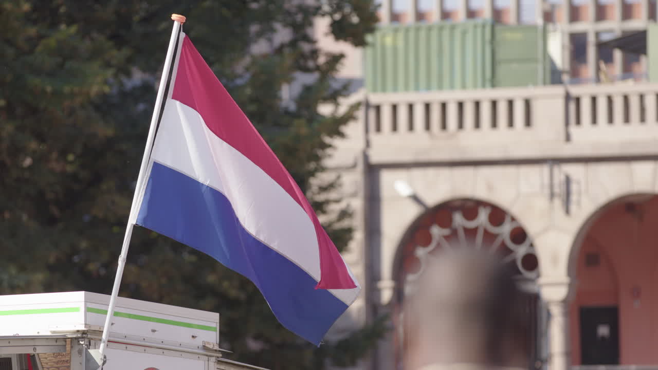 The Netherlands national flag is flown from a market street seller on Torggata