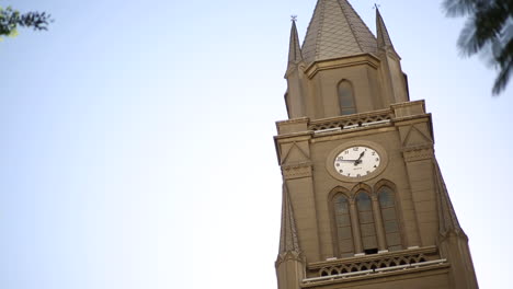 The-dome-of-an-old-church-on-which-the-wall-clock-hangs-from-the-outside---camera-tilt-down