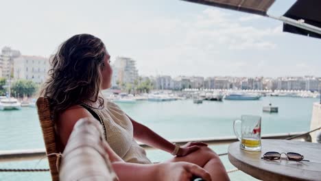cold beer in greece: woman enjoys a drink