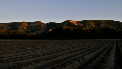 time lapse of the light diminishing on some mountains and a field as the sun sets