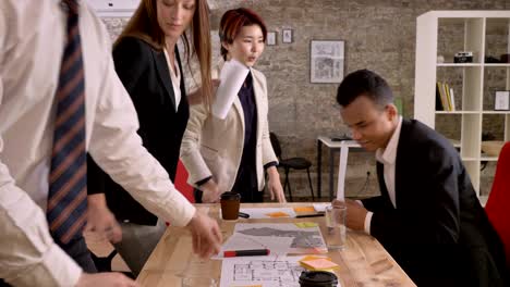 business team of 4 mixed race people finishing meeting in modern office building, everybody standing up and going away