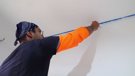 painter using brush to apply paint on wall - close up