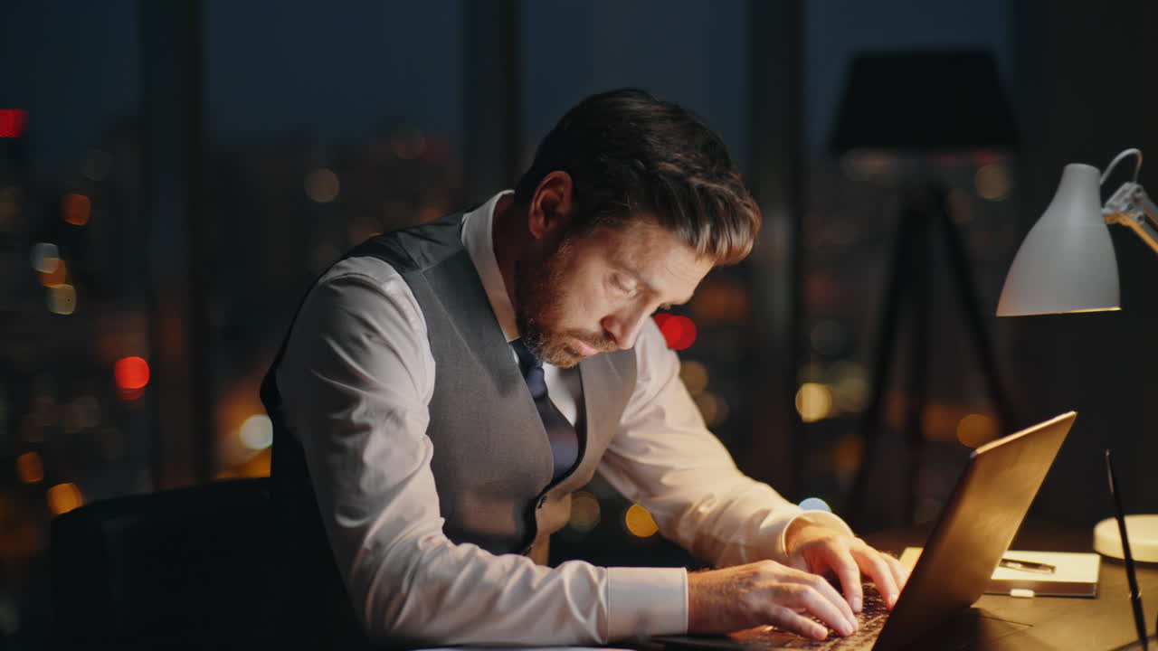 Busy employee working dark office at night. Focused boss typing computer online