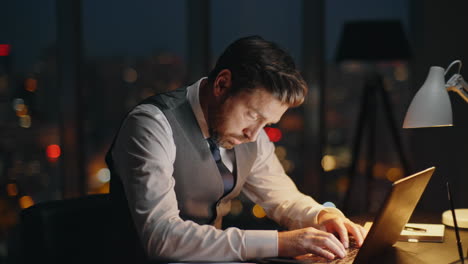 busy employee working dark office at night. focused boss typing computer online