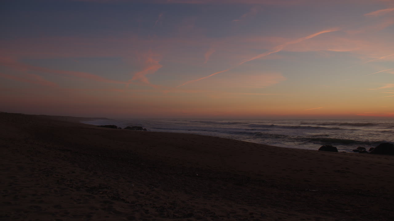 Romantic colors after sunset on sandy coast, handheld view