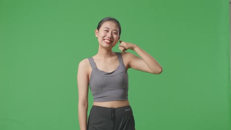 운동복 을 입은 여자 가 전화 로 몸짓 을 하고 있다