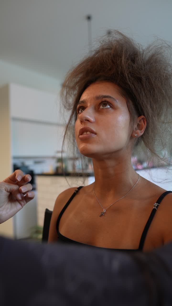 Primo piano di giovane donna mentre le viene preparato il viso