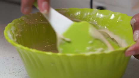 chef using spatula to make batter of cake mix