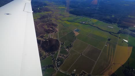 pov shot from a plane window, overlooking rural fields and highlands of california, usa