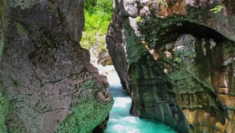 Faszinierender-Blick-Auf-Das-Türkisfarbene-Wasser-Des-Soca-flusses,-Der-Durch-Die-Enge-Schlucht-Zwischen-Riesigen-Felsbergen-Fließt