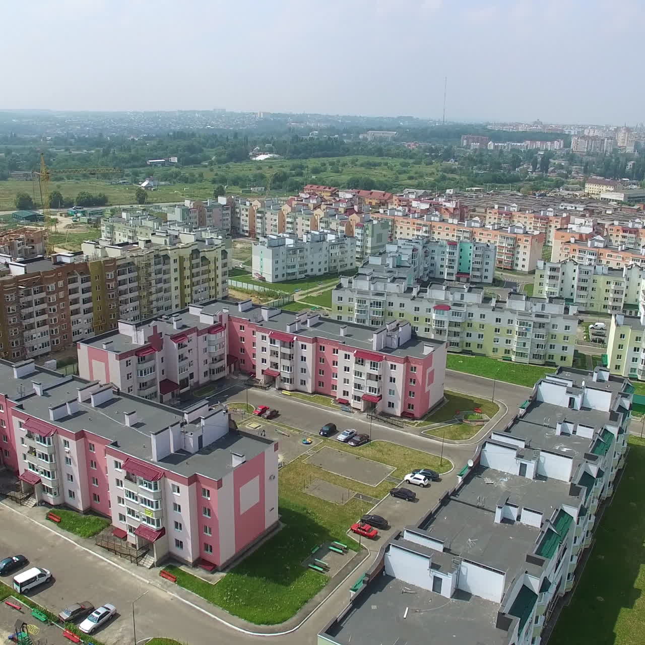Flying above new residential complex in the city in summer. Panoramic top view of modern buildings built in the new district. Aerial view