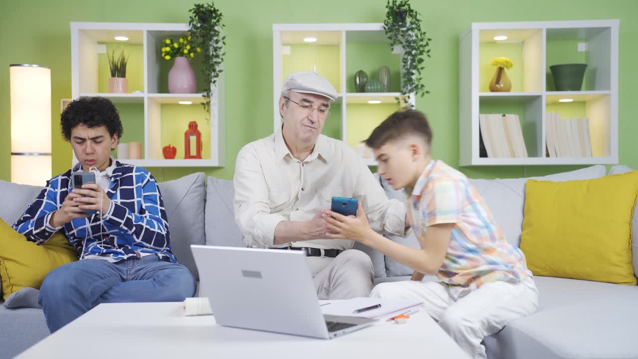 손자는 할아버지를 도와서 전화를 사용합니다.